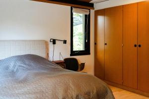 una camera da letto con un letto, una finestra e una sedia di Wild Nature Experience And Art In New Setting a Hornbæk