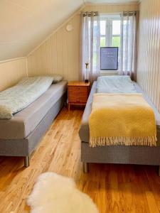 Un dormitorio con dos camas y una ventana. en Red Cottage By The Sea In Laukvika, en Laukvik 8 fotos más