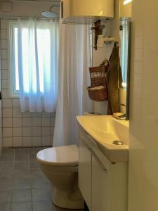 a bathroom with a toilet and a sink and a window at Family House With Large Garden Near Ebeltoft in Ebeltoft