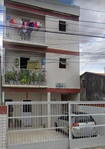 a building with a balcony with two cars on it at Ap 2 quartos com vaga de garagem in Campina Grande