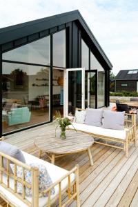 a screened in deck with a couch and a table at Newly Built Summer House With Sea View in Haderslev