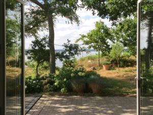 an open door with a view of a garden at Architect-Designed House With Private Beach in Løgstrup