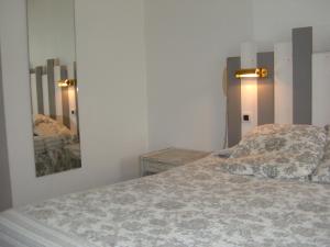 a bedroom with a bed and a mirror on the wall at Le Parasol in Ars-en-Ré