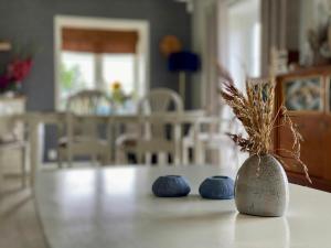 a vase with a plant in it sitting on a table at Enjoy Views In Helgeroa, Near The Beach in Helgeroa