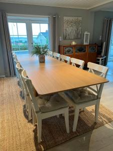 a large wooden table with chairs around it at Enjoy Views In Helgeroa, Near The Beach in Helgeroa