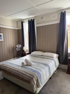 ein Schlafzimmer mit einem Bett, auf dem zwei Handtücher liegen in der Unterkunft Apsley Arms hotel in Walcha