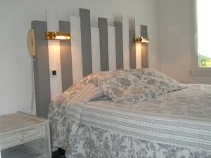 a bedroom with a bed with a wooden headboard at Le Parasol in Ars-en-Ré