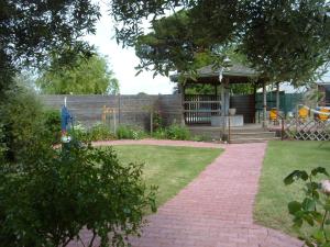 a garden with a pavilion and a brick walkway at Le Parasol in Ars-en-Ré