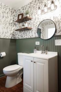 a bathroom with a toilet and a sink and a mirror at King Size Bed, Near Hwy, Work Desk, Close Parking in Lockport