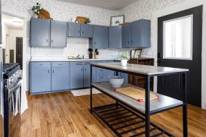 a kitchen with blue cabinets and a table in it at King Size Bed, Near Hwy, Work Desk, Close Parking in Lockport