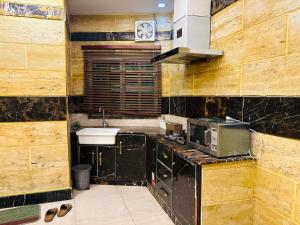 a kitchen with a sink and a microwave at Smart Apartment in Gullberg Lahore in Lahore