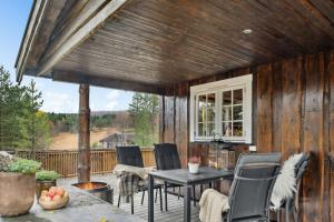 a patio with a table and chairs on a deck at Old Swiss Hotel Charm In Seljestad in Fannrem