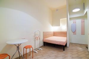 リヴィウにあるMini Apartments on Roppoporta 7a-2のベッド、テーブル、スツールが備わる客室です。