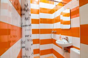 an orange and white bathroom with a sink and mirror at Mini Apartments on Roppoporta 7a-2 in Lviv