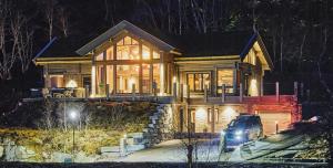 un coche aparcado delante de una casa por la noche en Luxury Cabin With Views, en Stranda