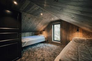 a bedroom with two beds in a wooden cabin at Modern Mountain Cabin Near Syningtoppen in Torpo