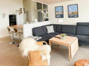 a living room with a blue couch and a table at Stunning Sunrises Over Harre Vig in Roslev