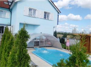 a swimming pool in front of a house at Penzion Buchmann in Františkovy Lázně