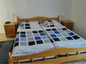 a bed with blue and white blankets and pillows on it at Penzion Buchmann in Františkovy Lázně