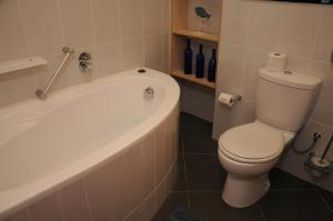 Un baño con inodoro blanco y bañera. en Moringa Gardens # 03 E, en Swakopmund 17 fotos más