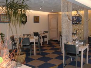 a restaurant with tables and chairs in a room at Le Parasol in Ars-en-Ré