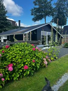 una casa con un jardín con flores delante en Split-Level Holiday Home With View Of Årø, en Haderslev
