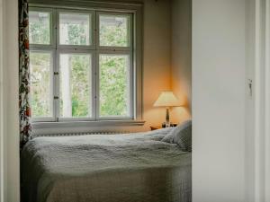 un dormitorio con una cama y una ventana en Unique Mission House By Lake Sommen, en Hult