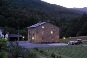 - un grand bâtiment en briques dans un terrain avec un ballon de football dans l'établissement Finca O Bizarro, à Trabada