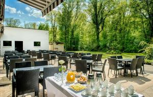 a dining area with tables and chairs and trees at Hôtel Marso in Amnéville