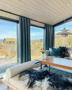 a living room with a couch and a large window at Stylish Mountain Cabin In Hallingdalen in Flå +29 photos