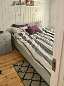 a bed in a room with a bed frame at Forest Cabin By The Sea Near Fredrikstad in Kråkerøy +2 photos