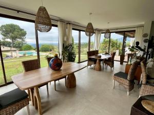 ein Wohnzimmer mit Tisch und Stühlen und Fenstern in der Unterkunft Provencal Villa With Pool And Panoramic Views in La Gaude