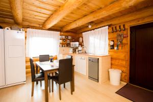 a kitchen with a table and chairs and a refrigerator at Wolf's House in Gura Rîului