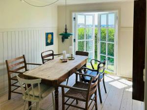 a dining room with a wooden table and chairs at Cottage With Glass Porch By Apelviken Beach in Varberg