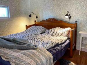 a bed in a bedroom with a bedspread on it at Country Cottage By Natural Pond In Söderköping in Gusum