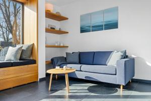 ein Wohnzimmer mit einem blauen Sofa und einem Tisch in der Unterkunft Light Flooded Holiday House On The Baltic Sea in Ahrenshoop
