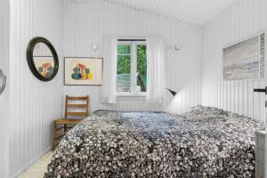 ein weißes Schlafzimmer mit einem Bett und einem Fenster in der Unterkunft Cozy Holiday Home Near The Beach And Nature in Frederiksværk