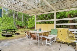 eine Terrasse mit Tisch und Stühlen unter einer Pergola in der Unterkunft Cozy Holiday Home Near The Beach And Nature in Frederiksværk