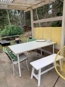 einen weißen Picknicktisch und Stühle auf einer Terrasse in der Unterkunft Cozy Holiday Home Near The Beach And Nature in Frederiksværk