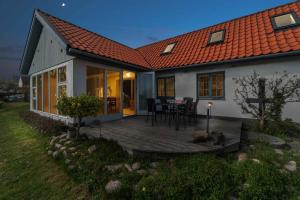 a wooden deck in front of a house at Holiday Home In Årsdale With Sea View in Svaneke