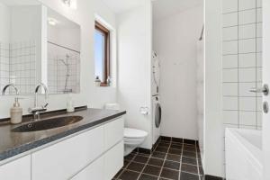 a white bathroom with a sink and a toilet at Beautiful Home In As Vig, 100 M From The Beach in Sønderby +22 photos