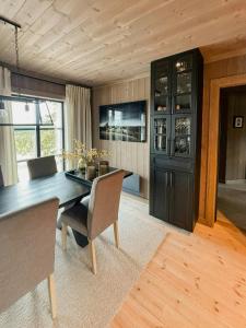 a dining room with a black table and chairs at Modern Cabin By Skeikampen's Ski Trails in Svingvoll