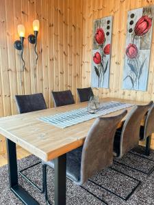 a wooden table with leather chairs around it at Seaside Cabin With Fjord Views In Skjerstad in Skjerstad +15 photos