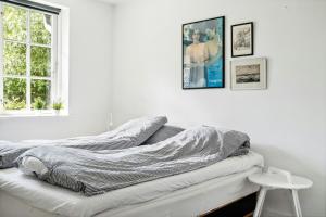two unmade beds in a white room with a window at Family Idyll Near Kikhavn Beach in Kikhavn