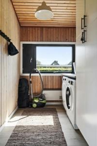 a washing machine in a room with a window at Find Peace In Cosiest Setting With Sea Glimpse in Assens +25 photos
