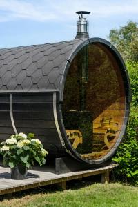 a building with a large circular window next to a plant at Cottage In Præstø With Sauna And Tub in Præstø