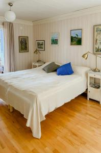 a large white bed in a room with wooden floors at Lake View Holiday Home With Natural Charm in Storfors +29 photos