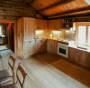 a kitchen with wooden cabinets and a stove at Historic Log Cabin By Rondane National Park in Lårgard