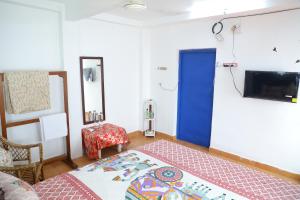 Zimmer mit einem Bett, einem TV und einem Sofa in der Unterkunft Eva Bliss-French Stay , 2mins Walk To Rock Beach in Puducherry