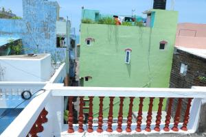 ein Balkon mit einem weißen Geländer und einem grünen Gebäude in der Unterkunft Eva Bliss-French Stay , 2mins Walk To Rock Beach in Puducherry